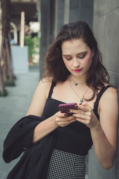 Moda joven usando el teléfono inteligente en las calles