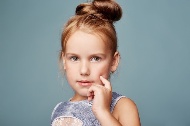 Moda linda garota posando em fundo azul, modelos de escolas. Retrato de uma garota emoções brilhantes, lindos cabelos e roupas. Adolescente, vento em seu cabelo. Rússia, Sverdlovsk, 25 de agosto de 2018