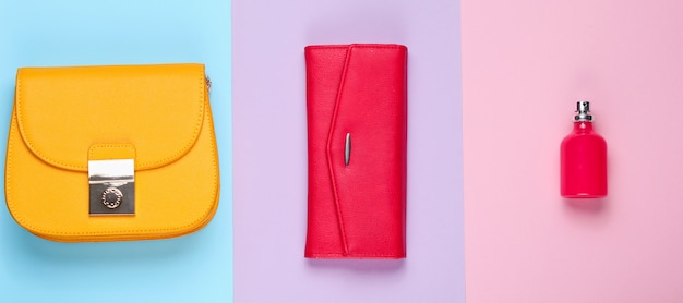 Moda minimalista. Complementos de moda para mujer. Monedero de cuero, bolso amarillo, frasco de perfume. Vista superior