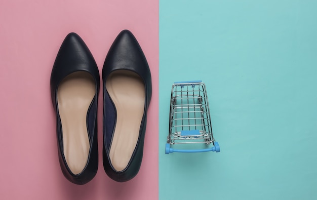Moda minimalista e conceito de compras carrinho de compras de sapatos de salto alto de couro em um fundo azul pastel