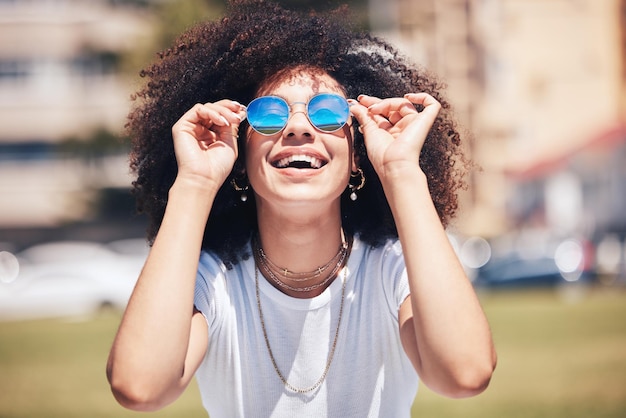 Moda de mujer y gafas de sol al aire libre en la ciudad para la felicidad de verano y vacaciones de viaje Cara de persona africana con cabello natural o afro en el parque natural con gafas y mentalidad positiva para la libertad