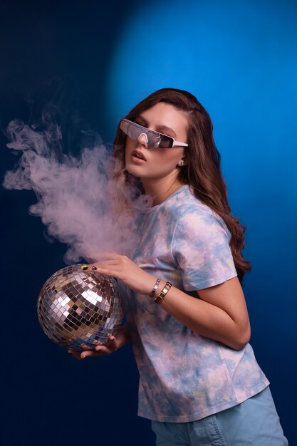 Moda mujer joven con bola de discoteca