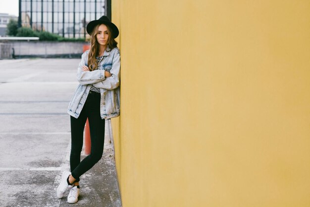 moda, mujer joven, llevando, sombrero, inclinar, fachada