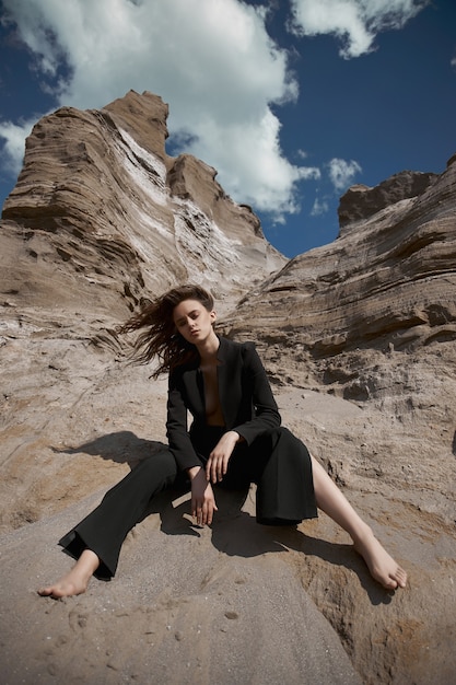 Moda mujer sexy en traje posando en rocas de arena