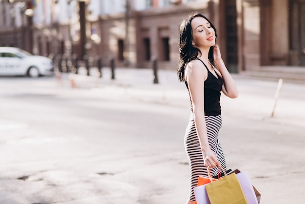 Moda mujer vestida con bolsas de colores en las calles, concepto de compras