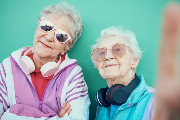 Moda de mujeres mayores y selfie retro con gafas de sol, auriculares y ropa vintage con una mentalidad genial al aire libre Retrato de ancianos estéticos o amigos juntos para una foto de perfil de arte pop