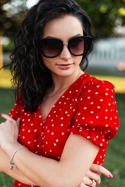 Moda mulher bonita com óculos vintage em vestido vermelho na rua