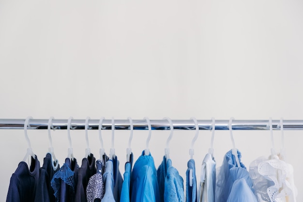 Moda rápida moda sustentável guarda-roupa minimalista variedade de roupas azuis femininas penduradas