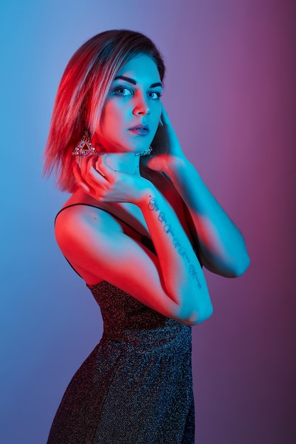 Moda retrato menina luz lâmpadas de néon vermelho azul. mulher posando em fundo colorido, bela maquiagem. rússia, sverdlovsk, 20 de abril de 2019