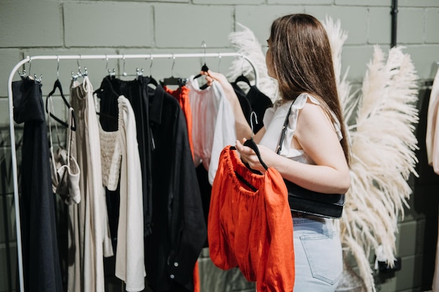 Moda sostenible Compras conscientes de la moda lenta Mujer joven latina comprando ropa moderna