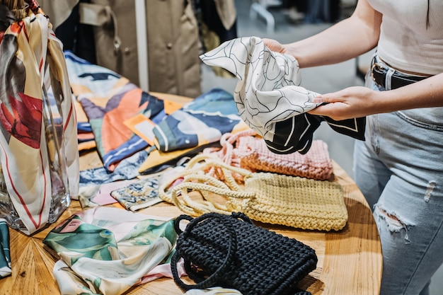 Foto moda sostenible mujer joven latina moderna eligiendo bufanda vintage accesorios de segunda mano en tienda vintage en centro comercial