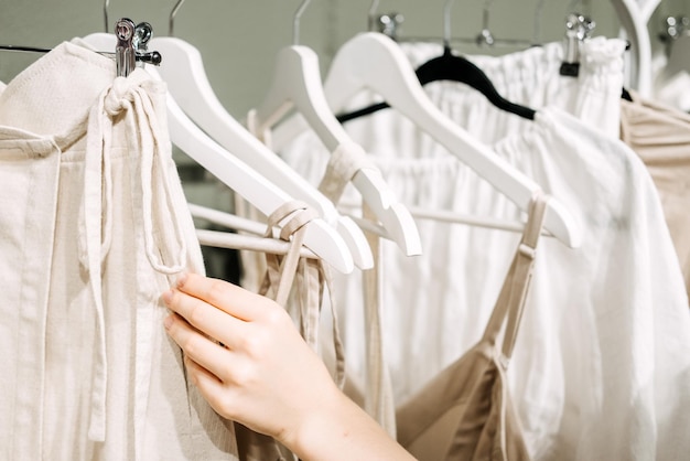 Moda sustentável, moda lenta, close-up da mão feminina pegando o rack de roupas com natural