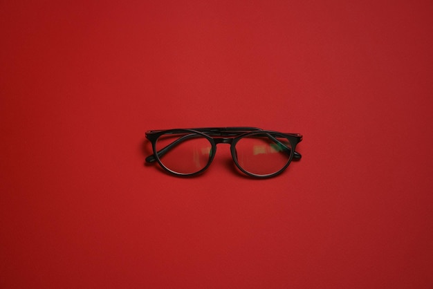 Mode-Brillenstil im Plastikkartenstil isoliert auf dunkelrotem Hintergrund