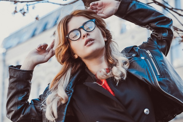 Mode-Hipster-Porträt der jungen schönen blonden Frau, die im Sommer im Freien posiert