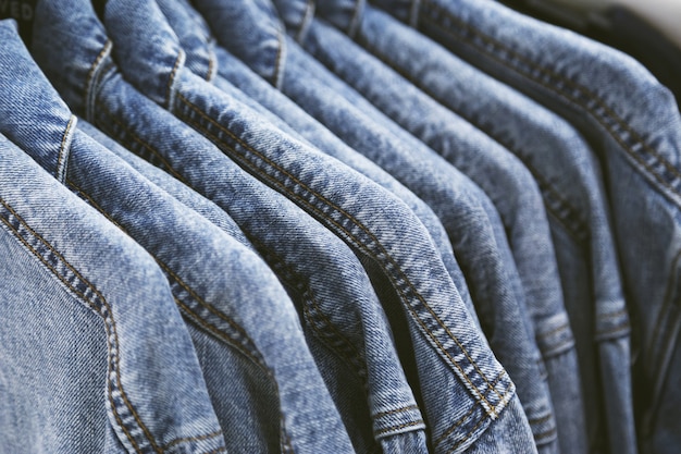 Foto mode jeansjacke auf kleiderbügeln.