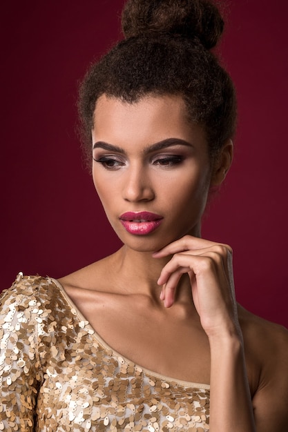 Mode junge afrikanische Frau mit Make-up im sexy Goldkleid
