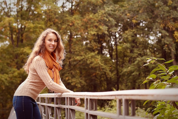 Mode junge Frau auf Brücke im Herbstpark