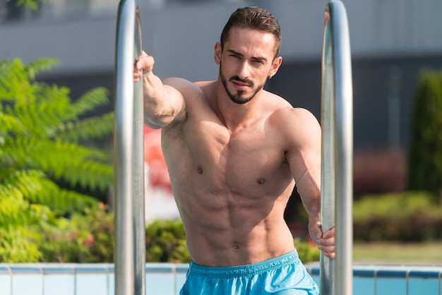 Mode-Porträt eines sehr muskulösen sexy Mannes in Unterwäsche am Swimmingpool