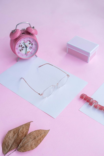 Mode- und Schönheitskonzept, das flach mit quadratischen Brillen Damenaccessoires auf rosa Hintergrund liegt