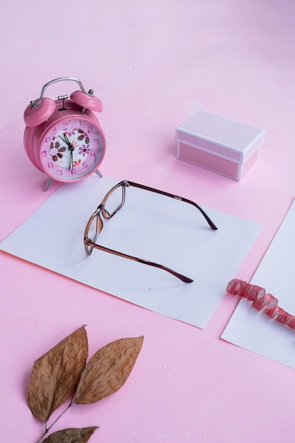 Mode- und Schönheitskonzept, das flach mit quadratischen Brillen Damenaccessoires auf rosa Hintergrund liegt