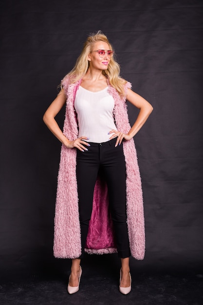 Mode- und Schönheitskonzept - Schöne blonde Frau, gekleidet in weißes Hemd und rosa Strickjacke vorbei