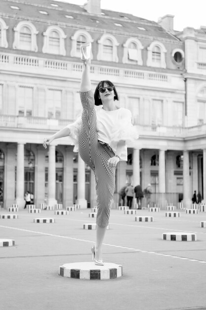 Mode und Vogue Sinnliche Frau mit brünetten Haaren Frau posiert auf Schuhen mit hohen Absätzen in Paris, Frankreich Schönheitsmädchen mit Glamour-Look Mode-Modell mit Sonnenbrille auf Platz Yoga- und Sportkonzept