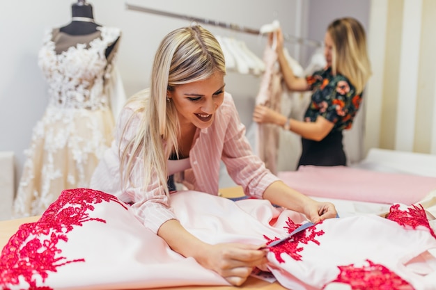 Modedesigner, die im Salon zum Nähen von Brautkleidern arbeiten.