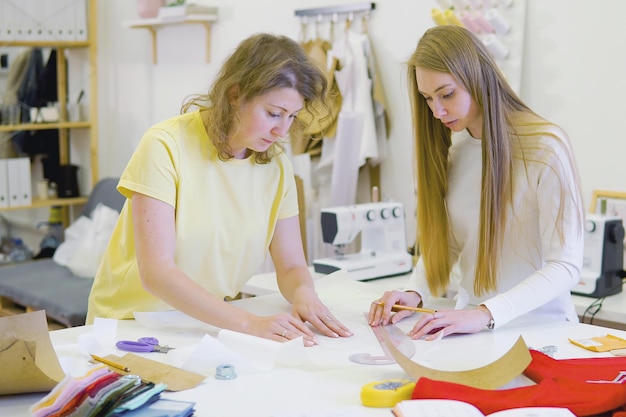 Foto modedesigner, die im salon zum nähen von brautkleidern arbeiten