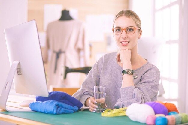 Modedesigner, die im Studio arbeiten, das auf dem Schreibtisch sitzt