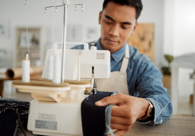 Modedesigner junger Mann und Schneider in einer kreativen Werkstatt zum Nähen von Kleidung und Kleidungsstücken Fabrikarbeiter Student und Lehrling lernen Nähmaschinenkenntnisse in einem Textil- und Fertigungsstudio