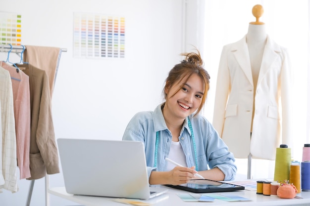 Modedesignerin, die im Studio arbeitet, Zeichnung schneidet, Kleid näht