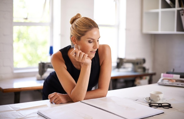 Foto modedesignerin und sketch-zeichnerin oder kreative ideen für die kleidungsproduktion an einem werkstattschreibtisch junge arbeiterin oder künstlerin im textilgeschäft mit inspiration und brainstorming