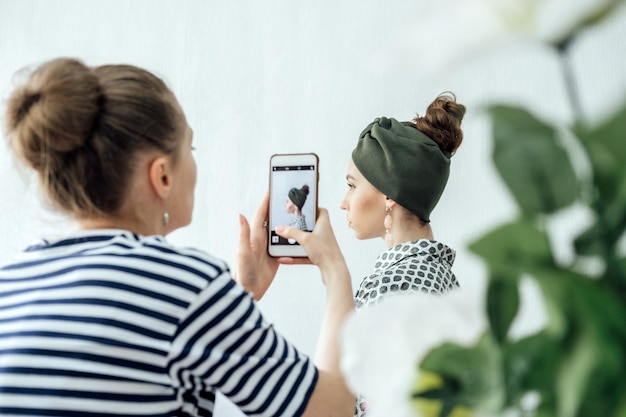 Modedesignerinnen, die mit Handy- oder Smartphone-Digitalkamera Fotos zu Accessoires machen