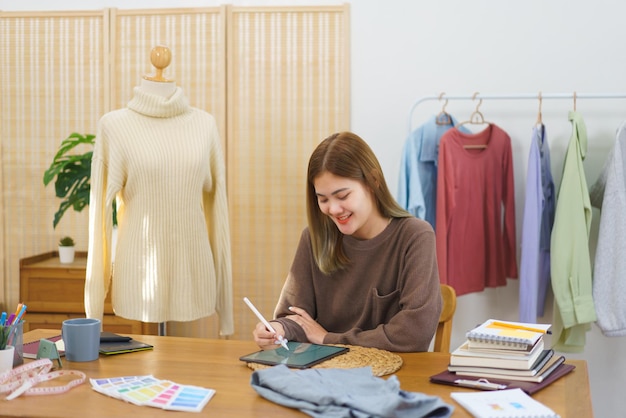 Modedesignkonzept Modedesigner skizziert neue Kollektionskleidung auf dem Tablet im Home Office