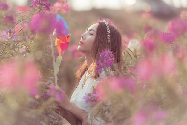 Modefoto im Freien der jungen schönen Dame in der Herbstlandschaft mit trockenen Blumen.