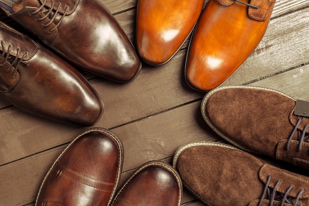 Modekonzept mit männlichen Schuhen auf Holzoberfläche