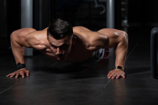 Model macht Liegestütze im Fitnessstudio