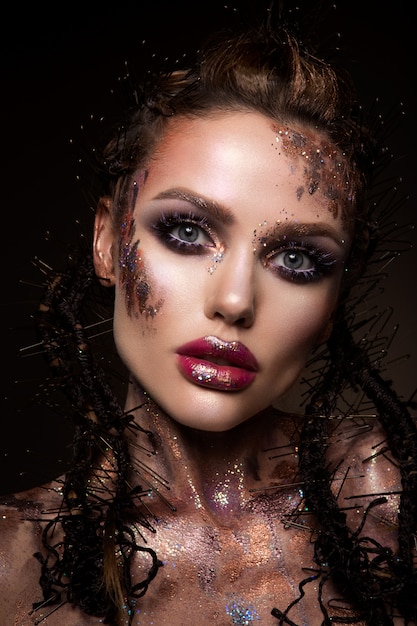 Model mit hellem Make-up und buntem Glitzer