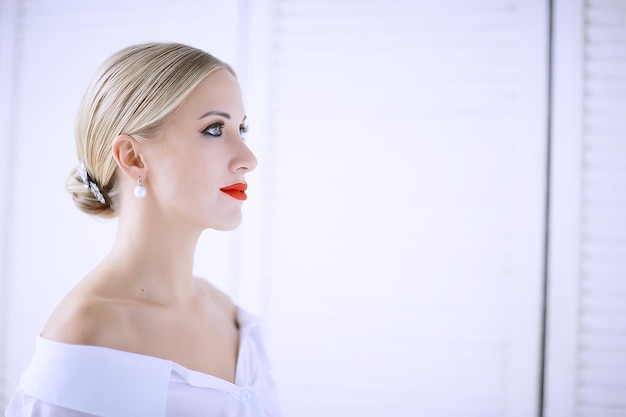 Model mit professionellem Make-up und knallroten Lippen / schönes Make-up im Gesicht des Models, gesättigt mit knallrotem Lippenstift auf den Lippen