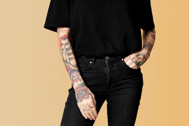 Model mit Tattoo in schwarzem T-Shirt und Jeans