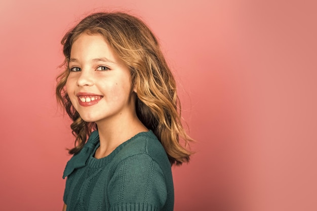 Model und Beauty-Look. Kleines Mädchen mit langen Haaren. Friseur, Hautpflege, Casual Style, Denim. Schönheits- und Kindermode mit gesundem Haar. Stilvolles Mädchen mit hübschem Gesicht auf grauem Hintergrund.