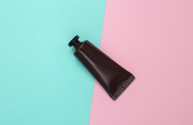 Modelagem de tubo de creme preto em fundo azul rosa Vista superior Colocação plana