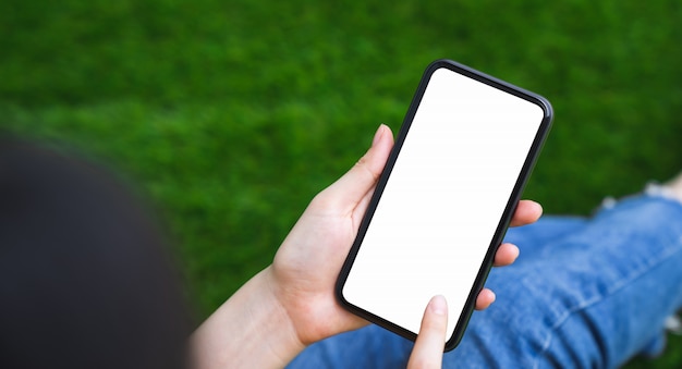 Modell der frauenhand, die smartphone hält und leeren bildschirm berührt.
