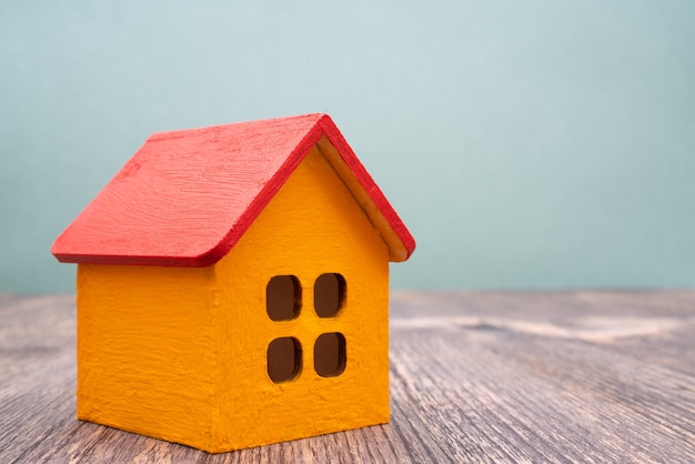 Modell eines gelben Holzhauses mit rotem Dach. Vermietung und Verkauf von Gebäuden und Ferienhäusern.