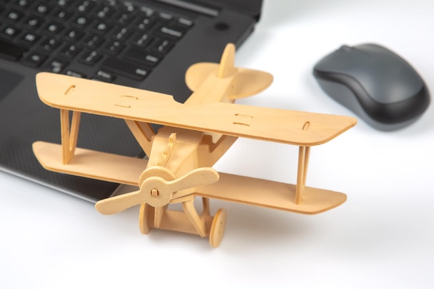 Modell eines Holzflugzeugs auf dem Hintergrund eines Laptops Geschäftsentwicklung und Erfolg Träumen Sie davon, in Ihrem Lieblingsgeschäft zu fliegen