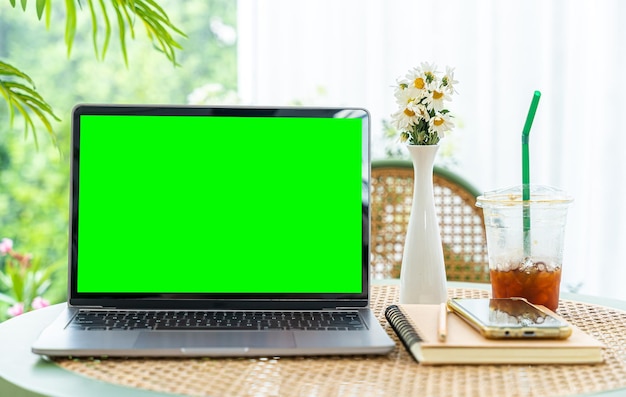 Modell eines Laptop-Computers mit leerem Bildschirm mit Notebookice-Kaffee und Smartphone auf der Tischseite des Fensters im Café am cafegreen-Bildschirm