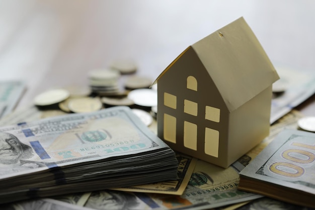 Modell eines Papphauses mit Schlüssel und Dollarscheinen Baudarlehen Immobilienkosten für den Wohnungsbau oder den Kauf eines neuen Wohnkonzepts