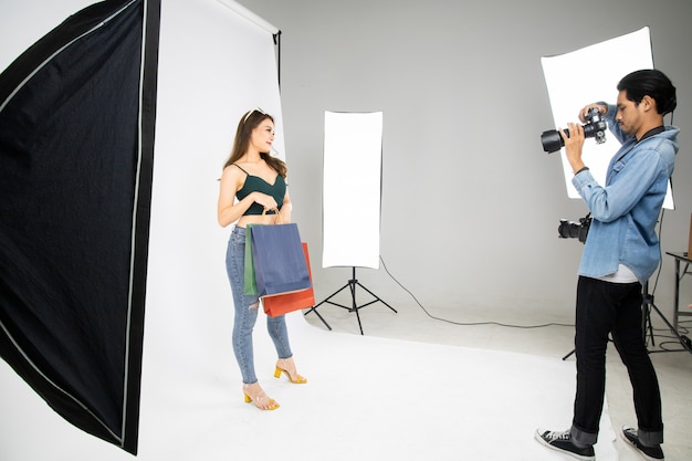 Foto modell junge frau, die für ein foto aufwirft, das mit einem professionellen fotografen im studio gemacht wird.