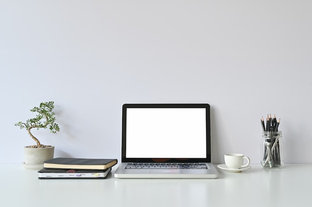 Modell Laptop-Computer und Bürobedarf und kleine Bonsai am Arbeitsplatz.