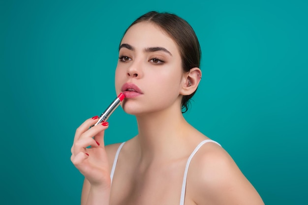 Modell Mädchen mit Lippenstift über Farbstudio Hintergrund Schönheit Frau Gesicht Kosmetik bilden Mode-Modell Lipgloss Make-up anwenden Sexy Frau Auftragen von Lippenstift auf Lippen